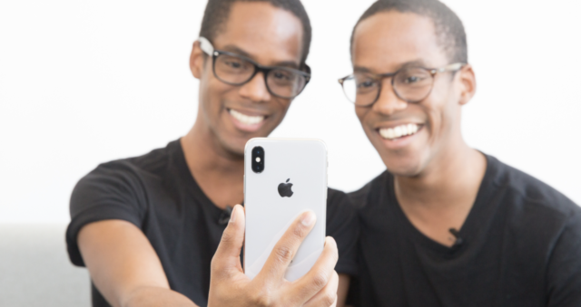 Tweelingen houden iPhone voor de gek tweeling voor de gek
